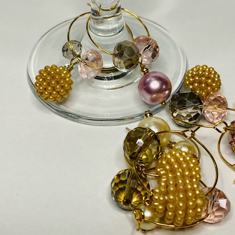 7 Wine glass charms. Gold rings adorned with pearl beads and crystal charms.